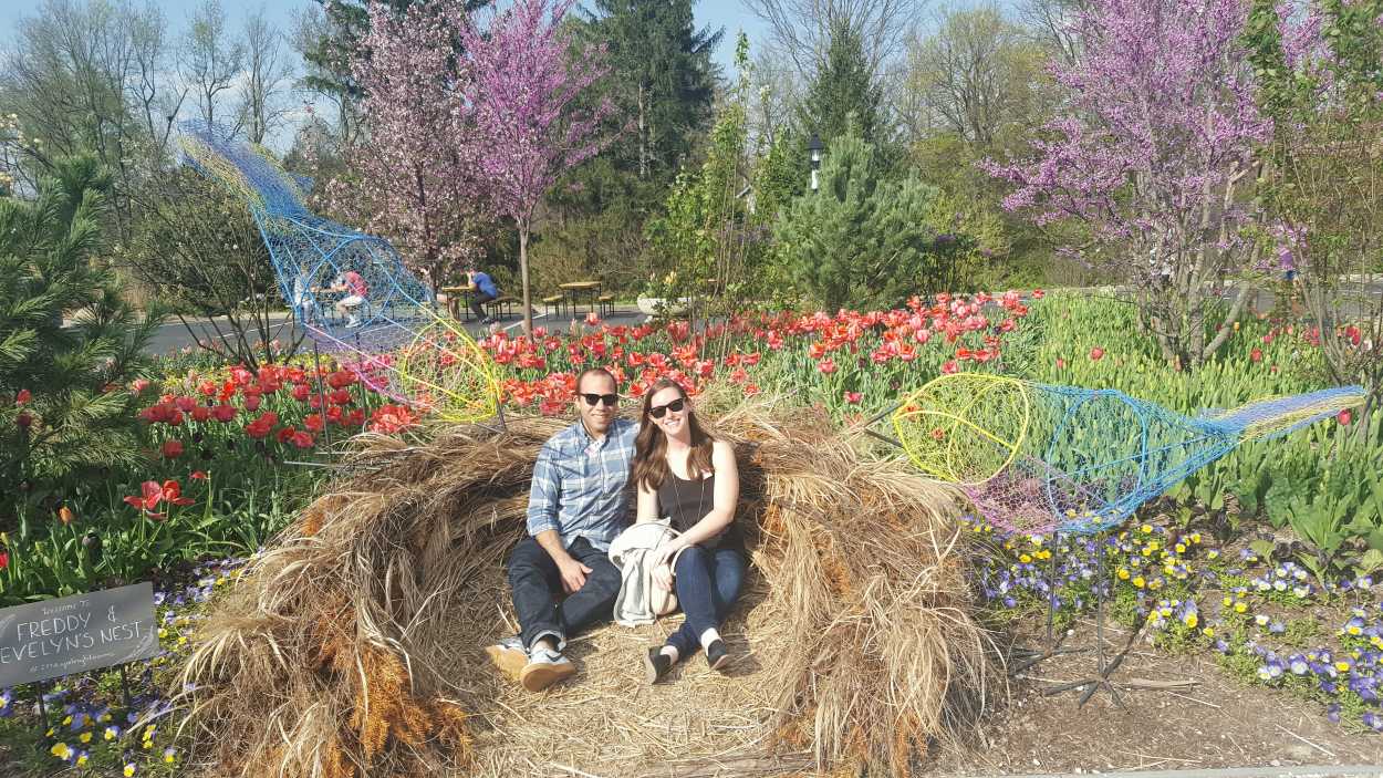 Alyssa and Michael sit in a bird cage sculpture