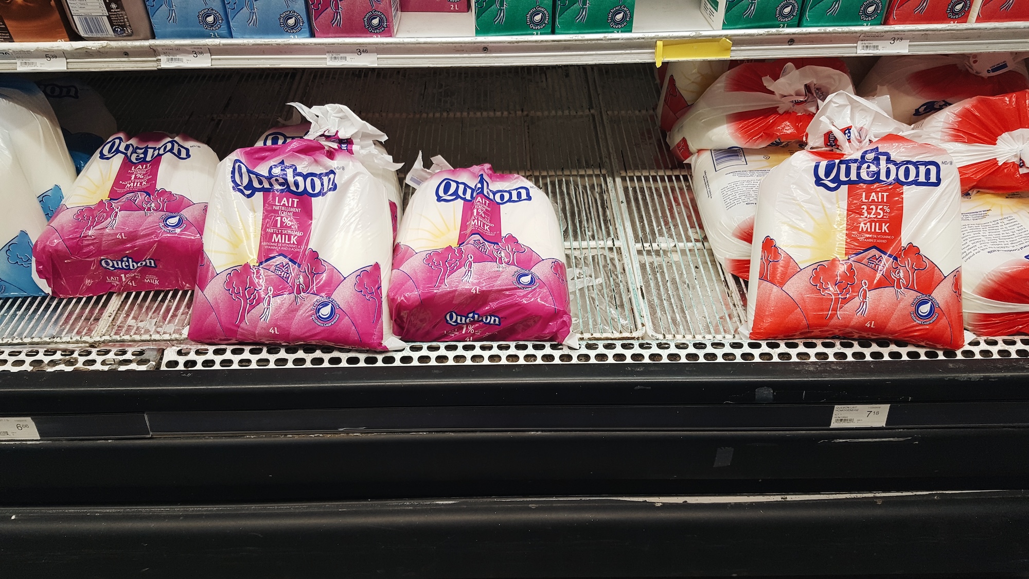 Bags of milk in the cooler at a grocery store