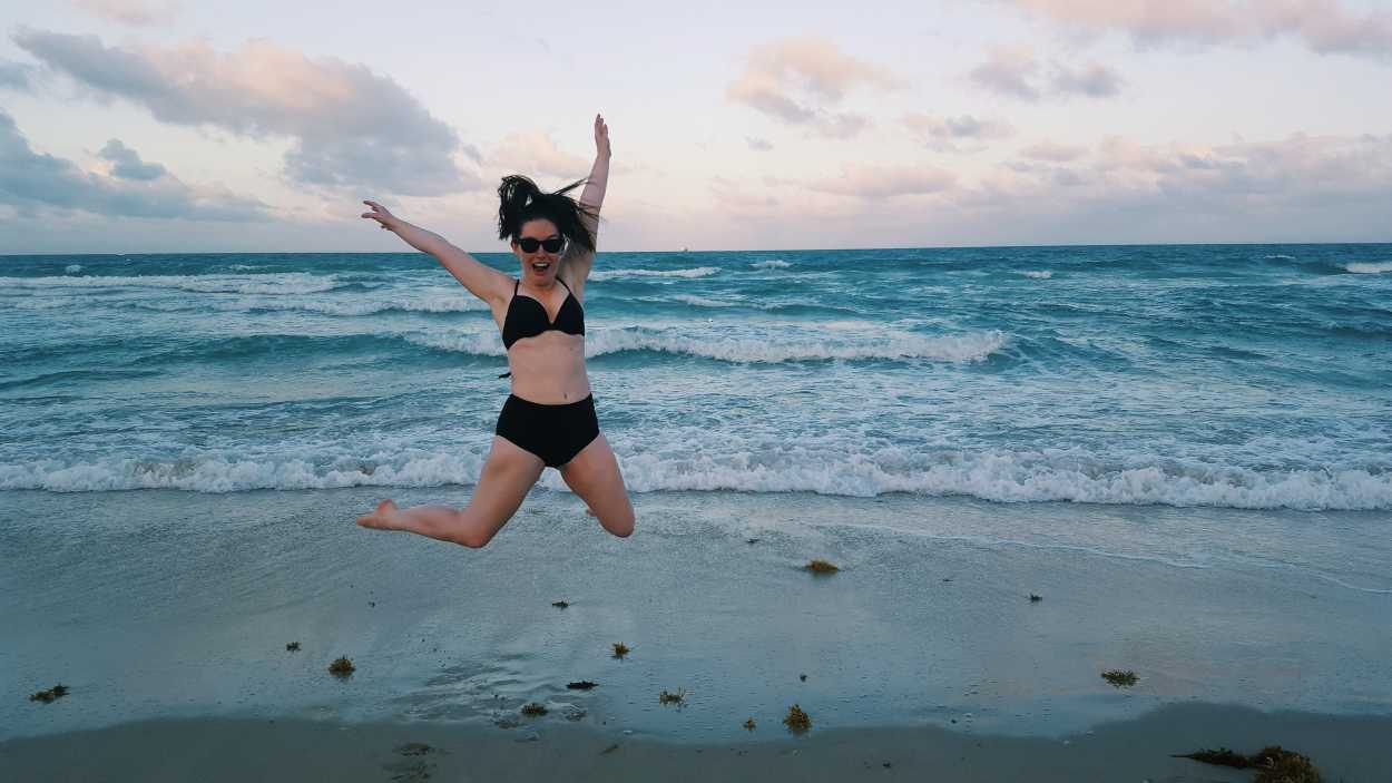 Alyssa jumps on the beach in Miami