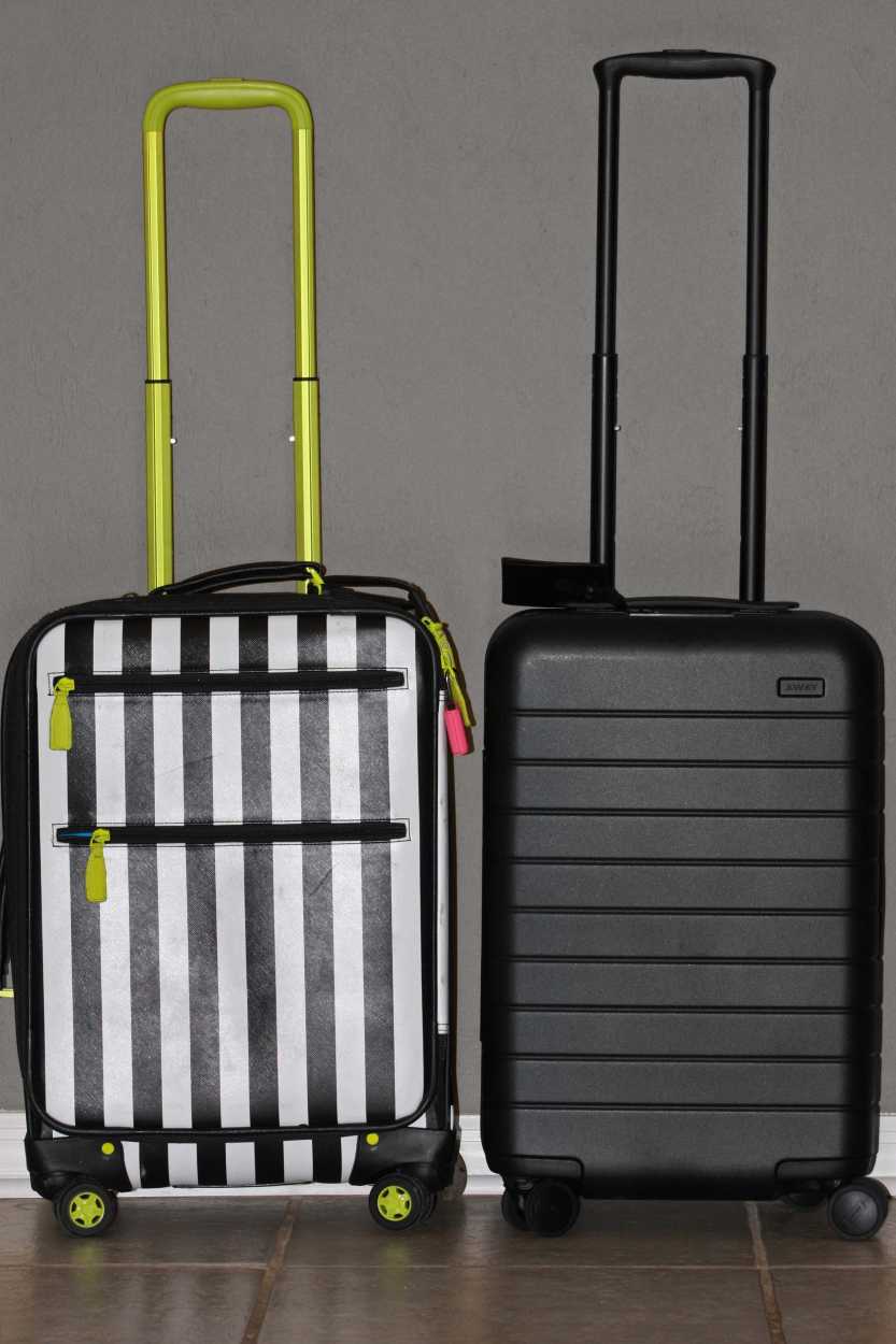 A striped suitcase and an Away Carry-on are placed side-by-side