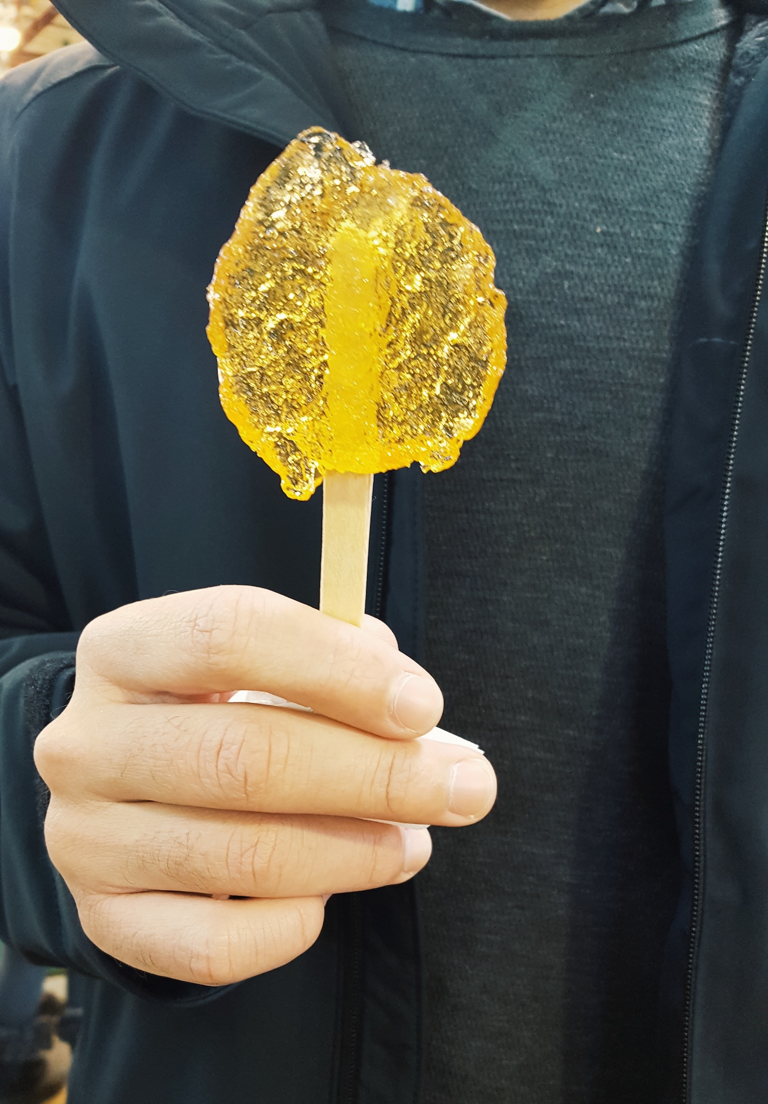 Michael holds a stick with maple snow taffy