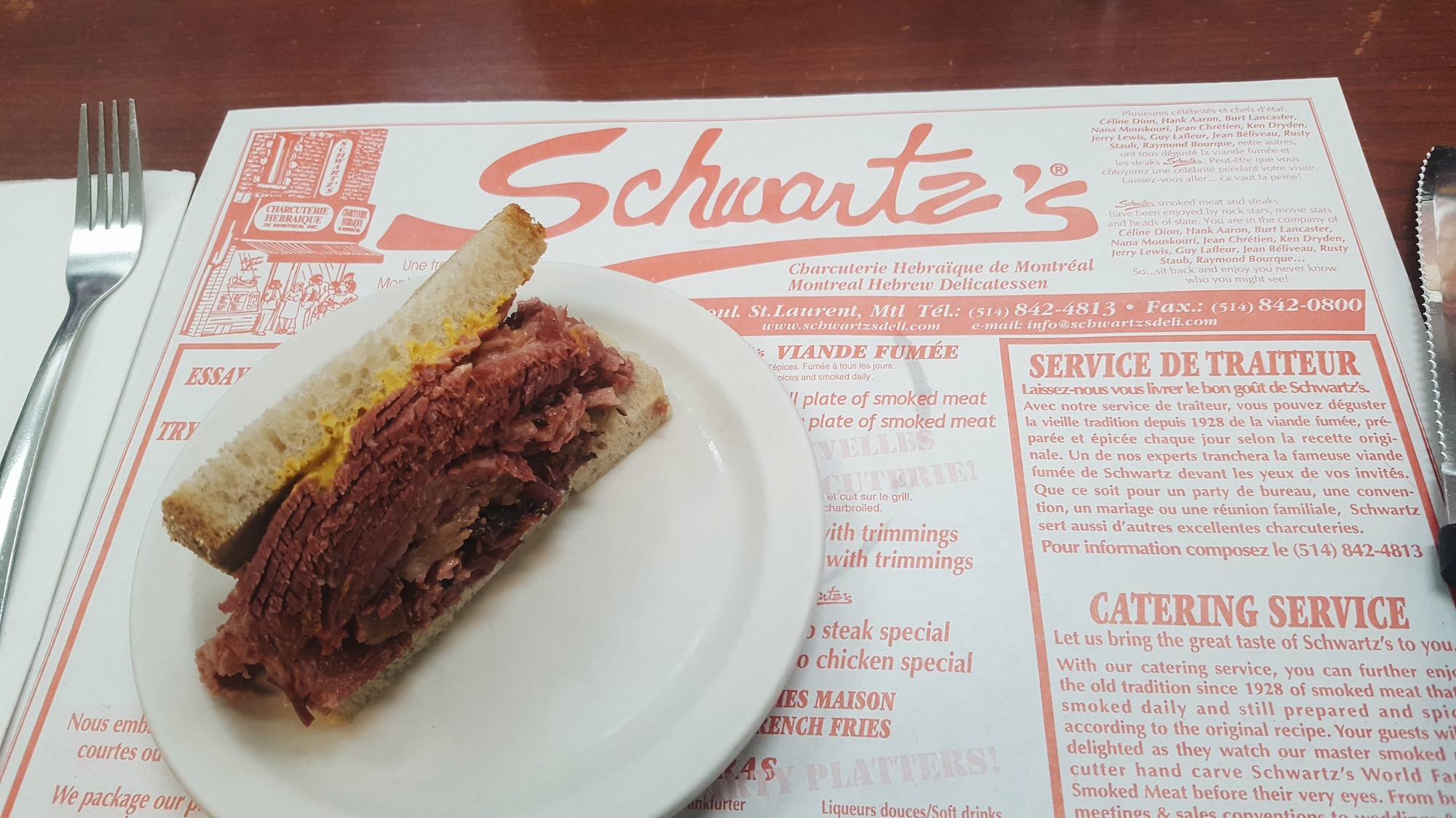 a smoked meat sandwich on top of a Schwartz's menu