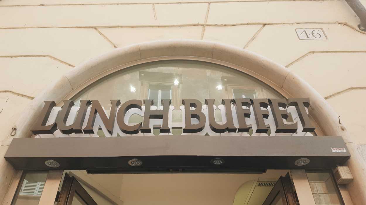 An arch over a doorway that reads "Lunch buffet" in Rome