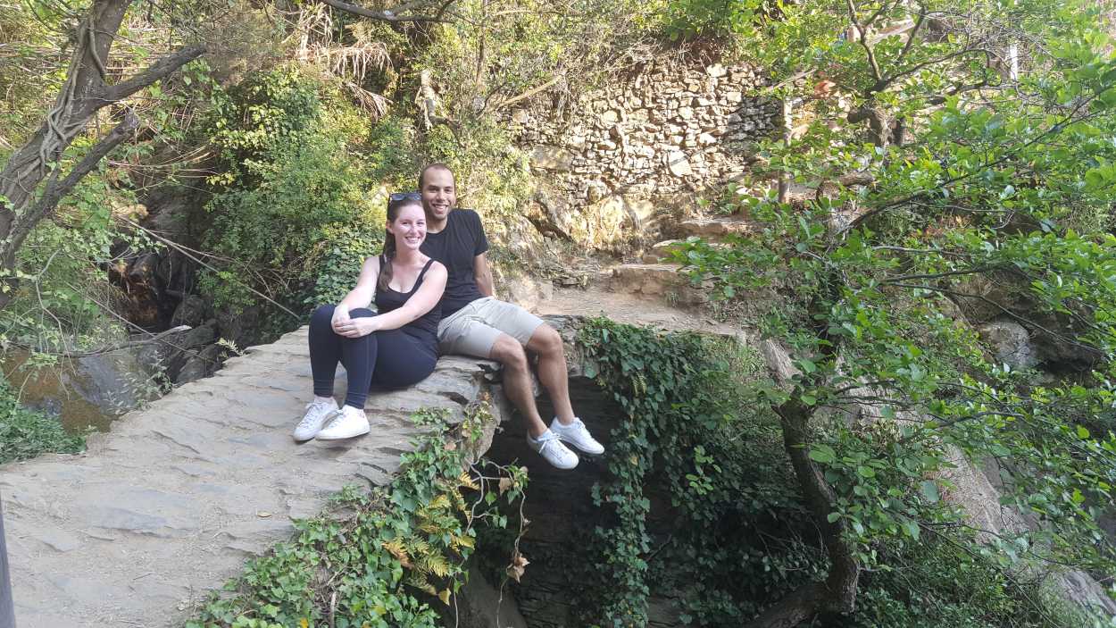 Alyssa and Michael sit on a foot bridge while hiking