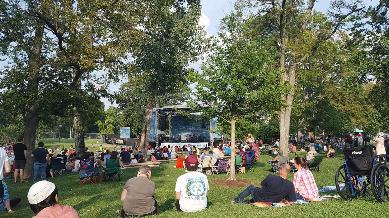 A crowd of people listening to music at Centennial Park