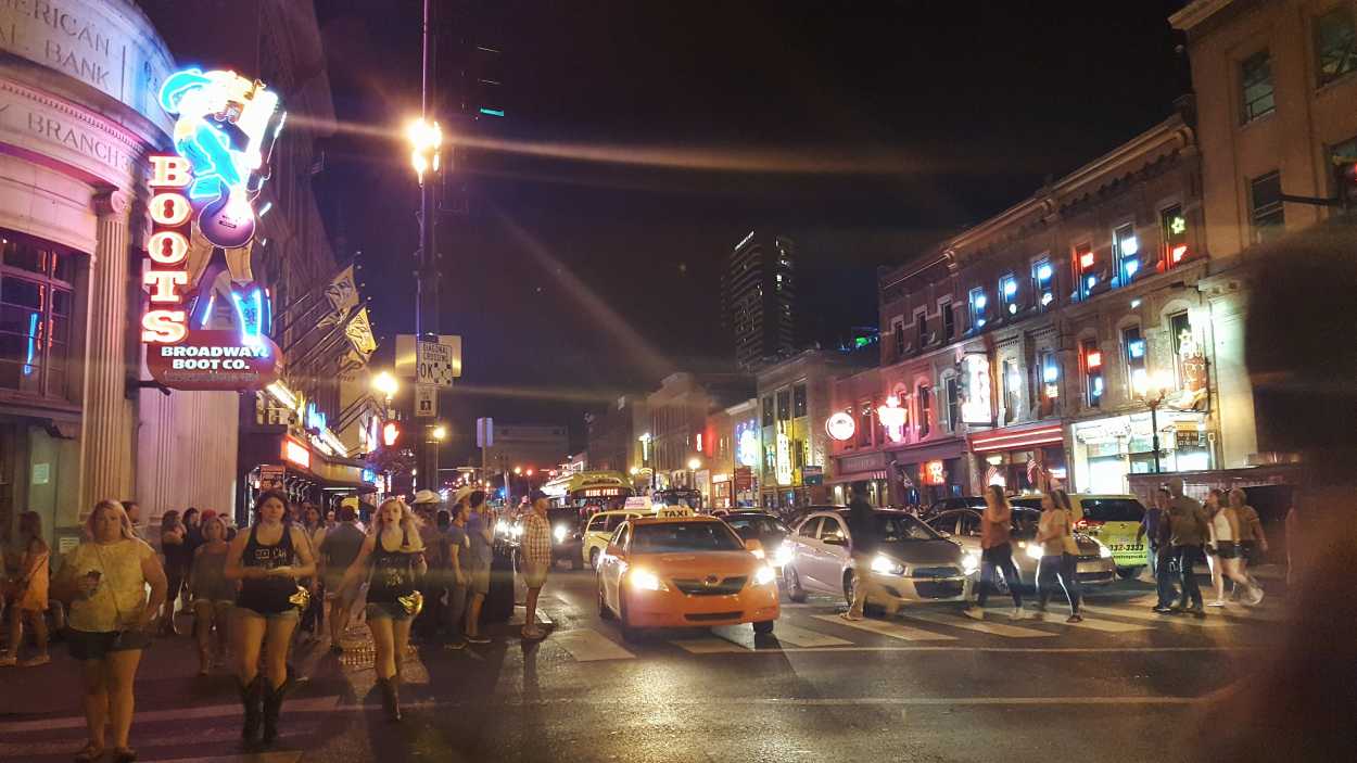 A crowd of people and cars on Broadway Street in Nashville