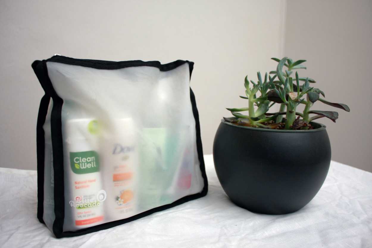 A quart bag from the brand Blue Avocado is filled with travel liquids