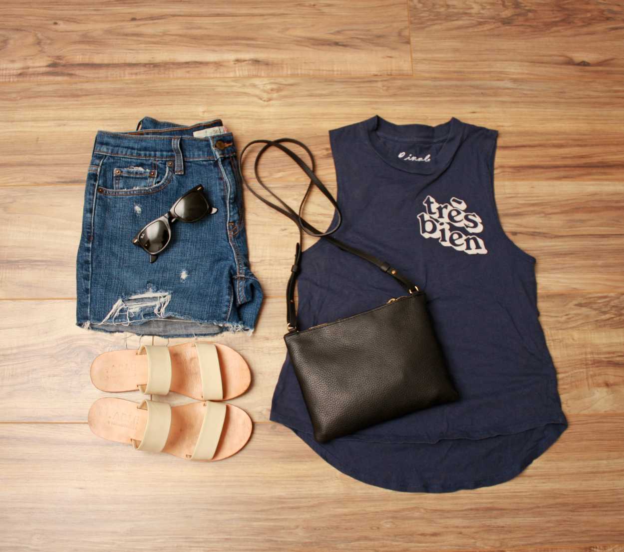 Nashville outfit Flat lay: graphic tank, white sandals, denim shorts, black purse