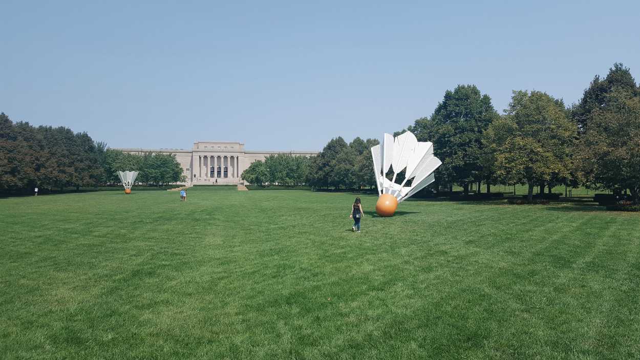 Alyssa runs toward a shuttlecock on the lawn of the Nelson-Atkins Museum