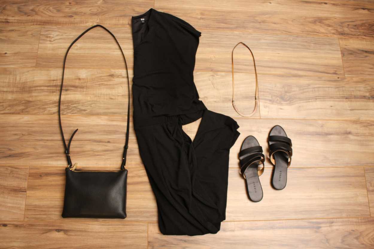 A jumpsuit, sandals, and purse are arranged on the floor in a flatlay