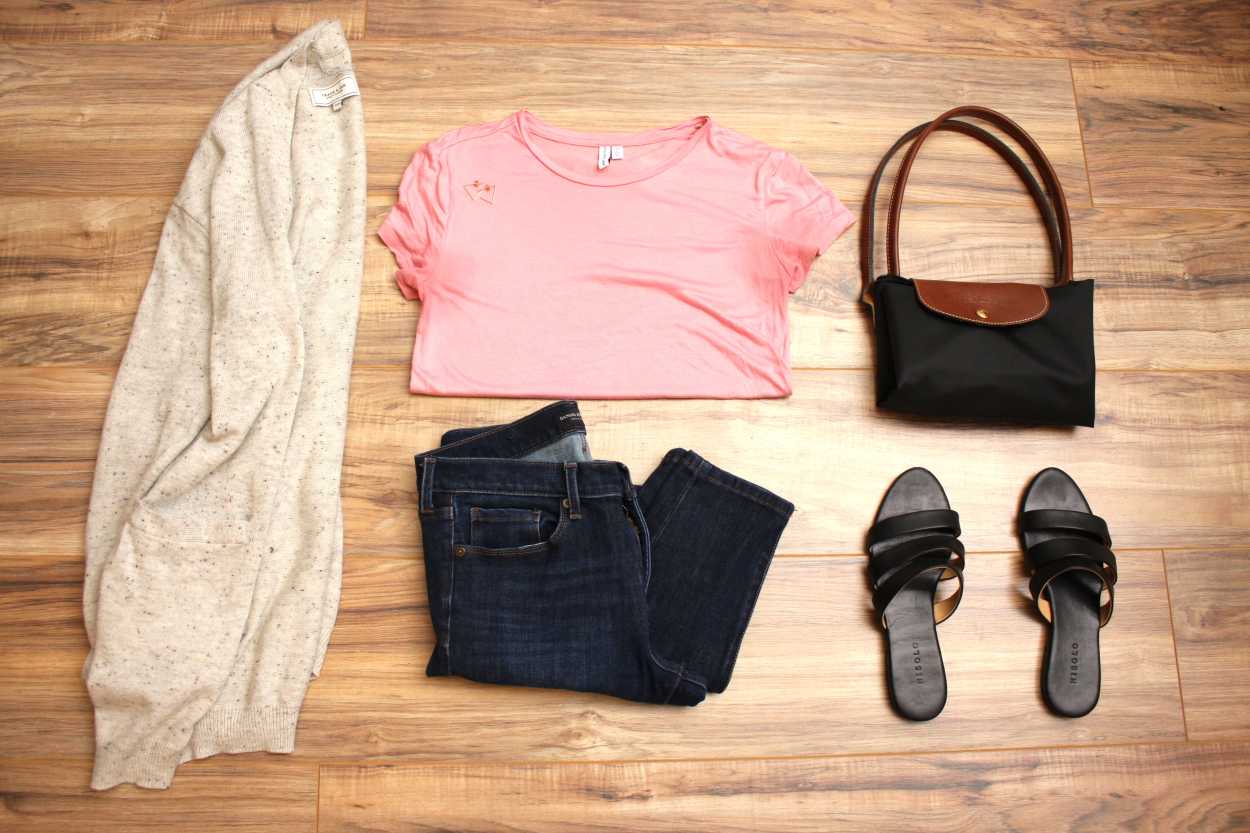 A tee, jeans, cardigan, sandals, and bag are arranged on a wood floor in a flatlay