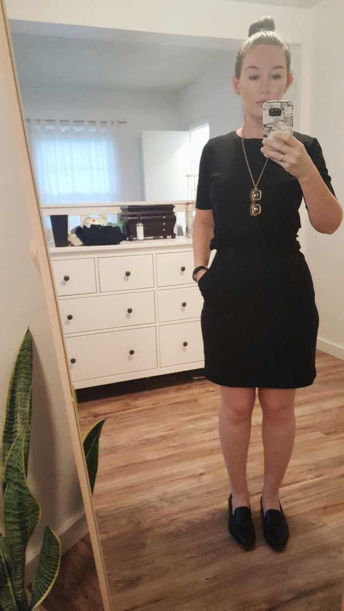 Alyssa wears a black dress with a black tee over it with black loafers in the morning