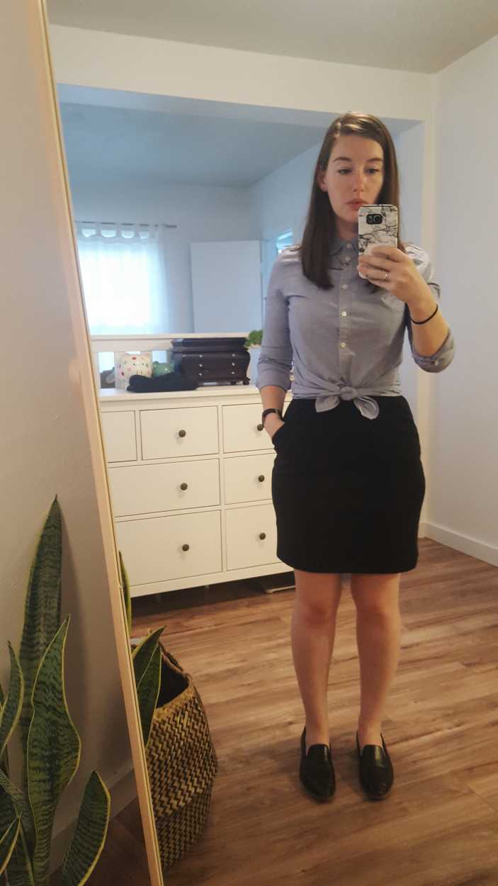 Alyssa wears a blue button-down tied in a knot over a black dress with loafers in the morning