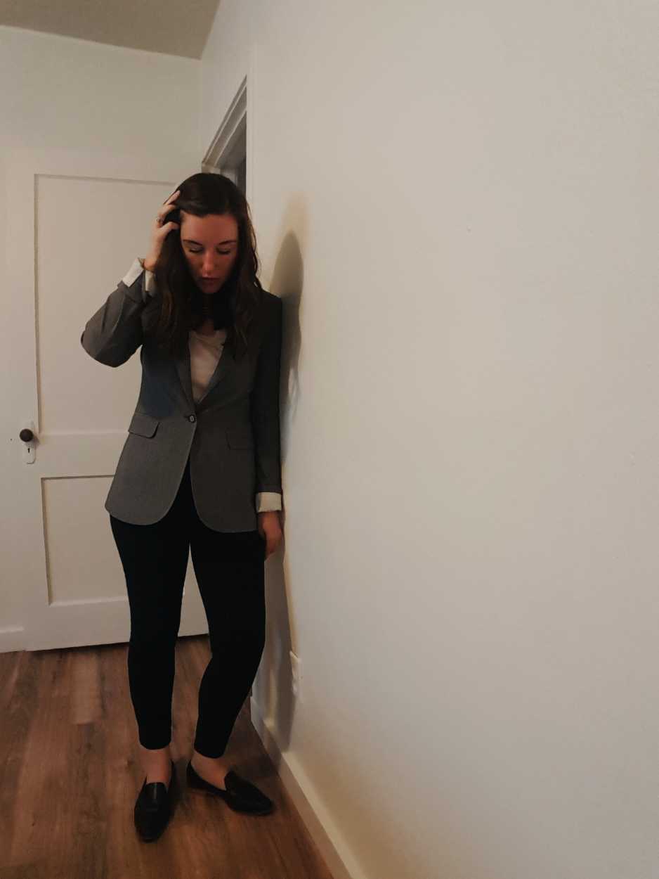 Alyssa wears a pink tee, black pants, black loafers and gray blazer