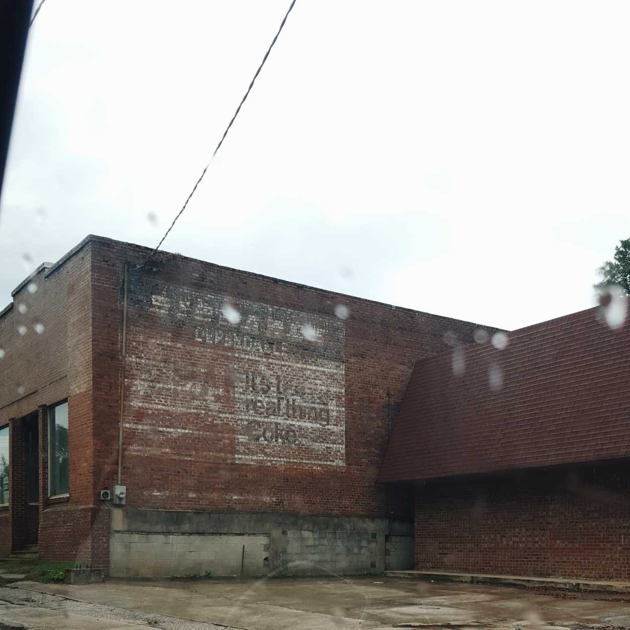 An old Coke mural on a brick building