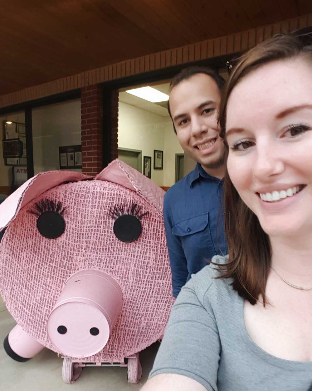 Alyssa and Michael in front of a large pig sculpture 
