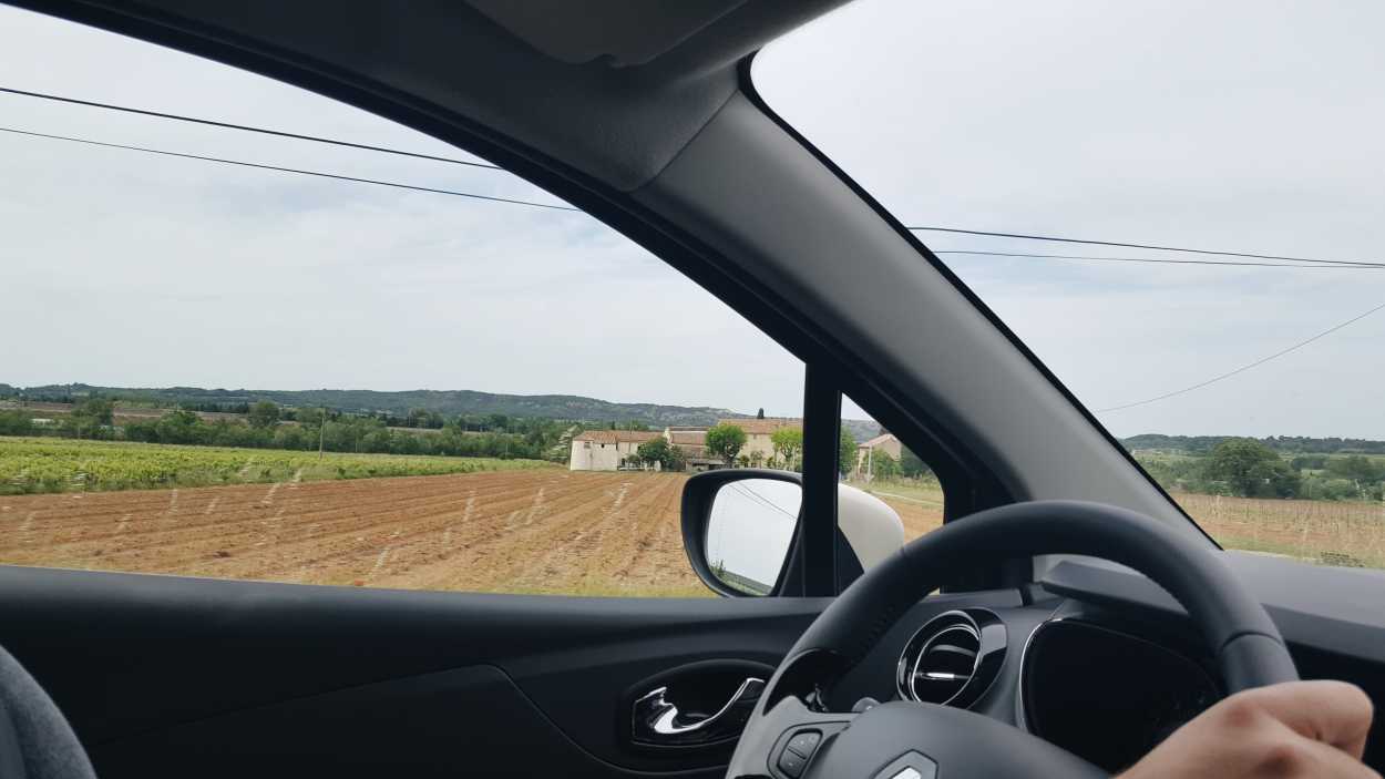 Michael's hands on the steering wheel as fields roll by