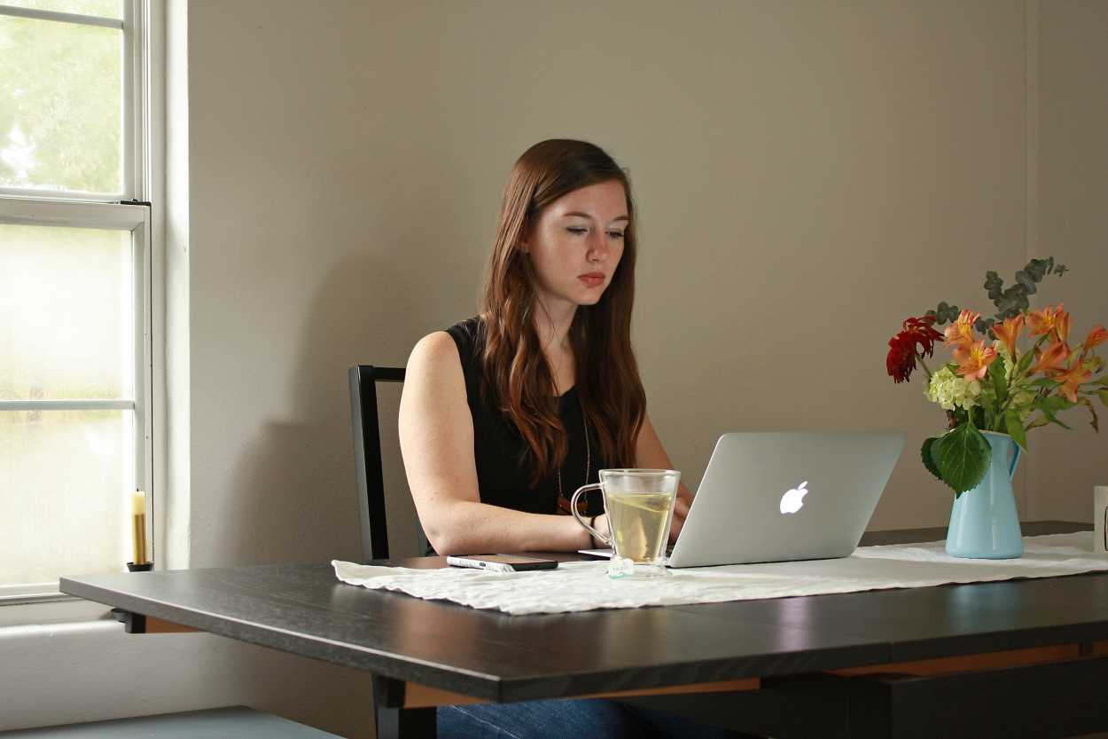 Alyssa sits at a laptop at the dining room table