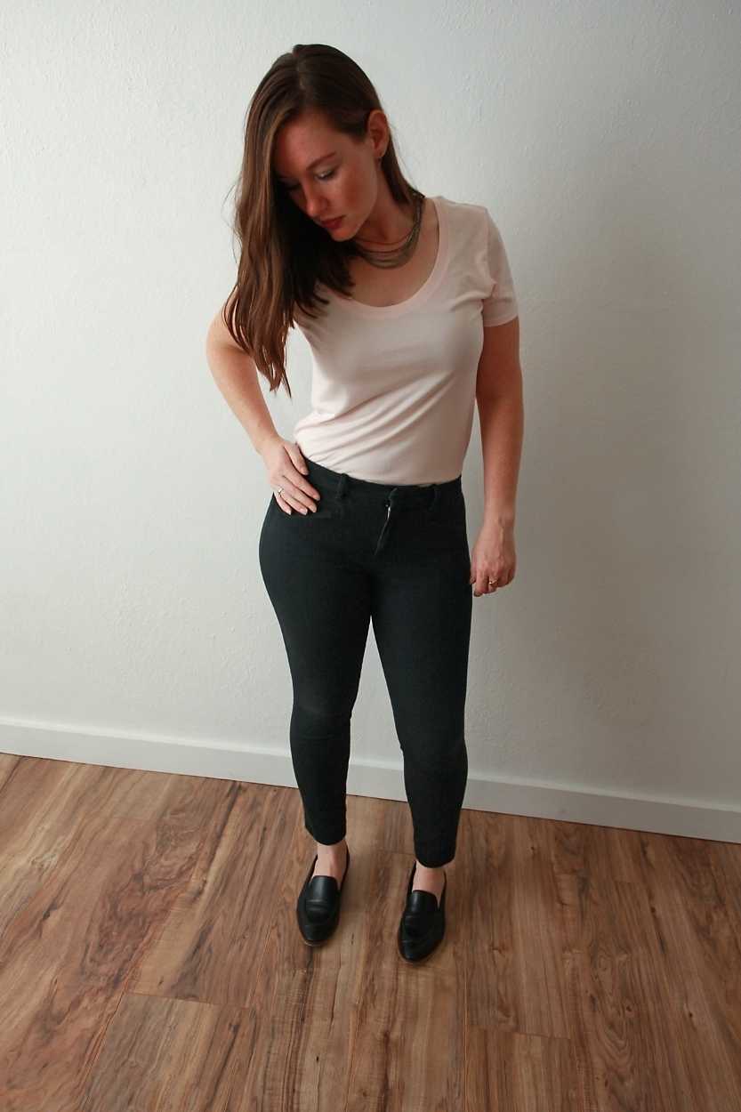 Alyssa wears pink tee, black pants, black loafers, and silver necklace