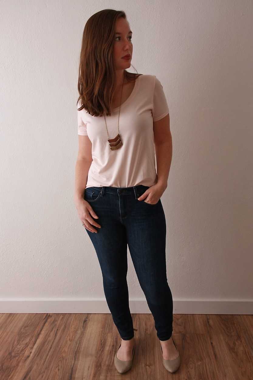 Alyssa wears a pink tee and blue jeans and puts her hand in her pocket
