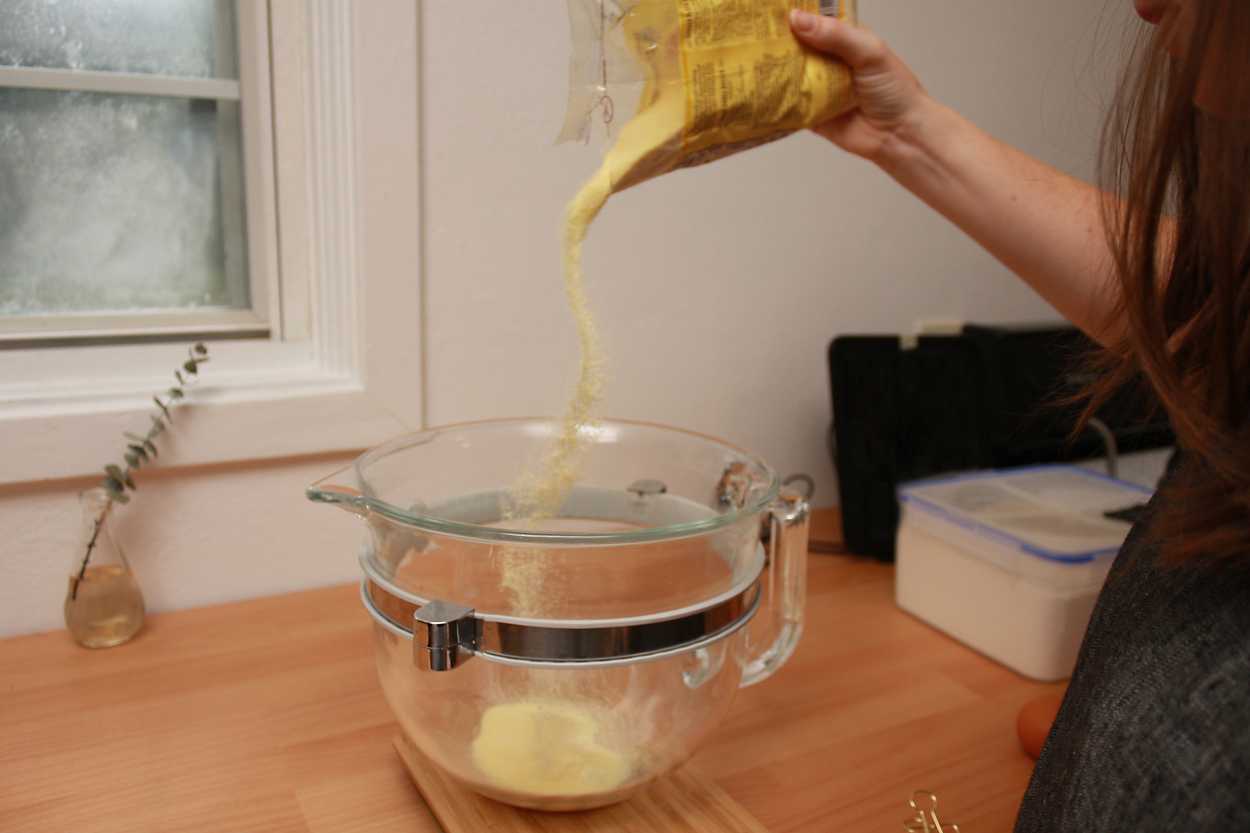 Alyssa sprinkles semolina flour in a bowl