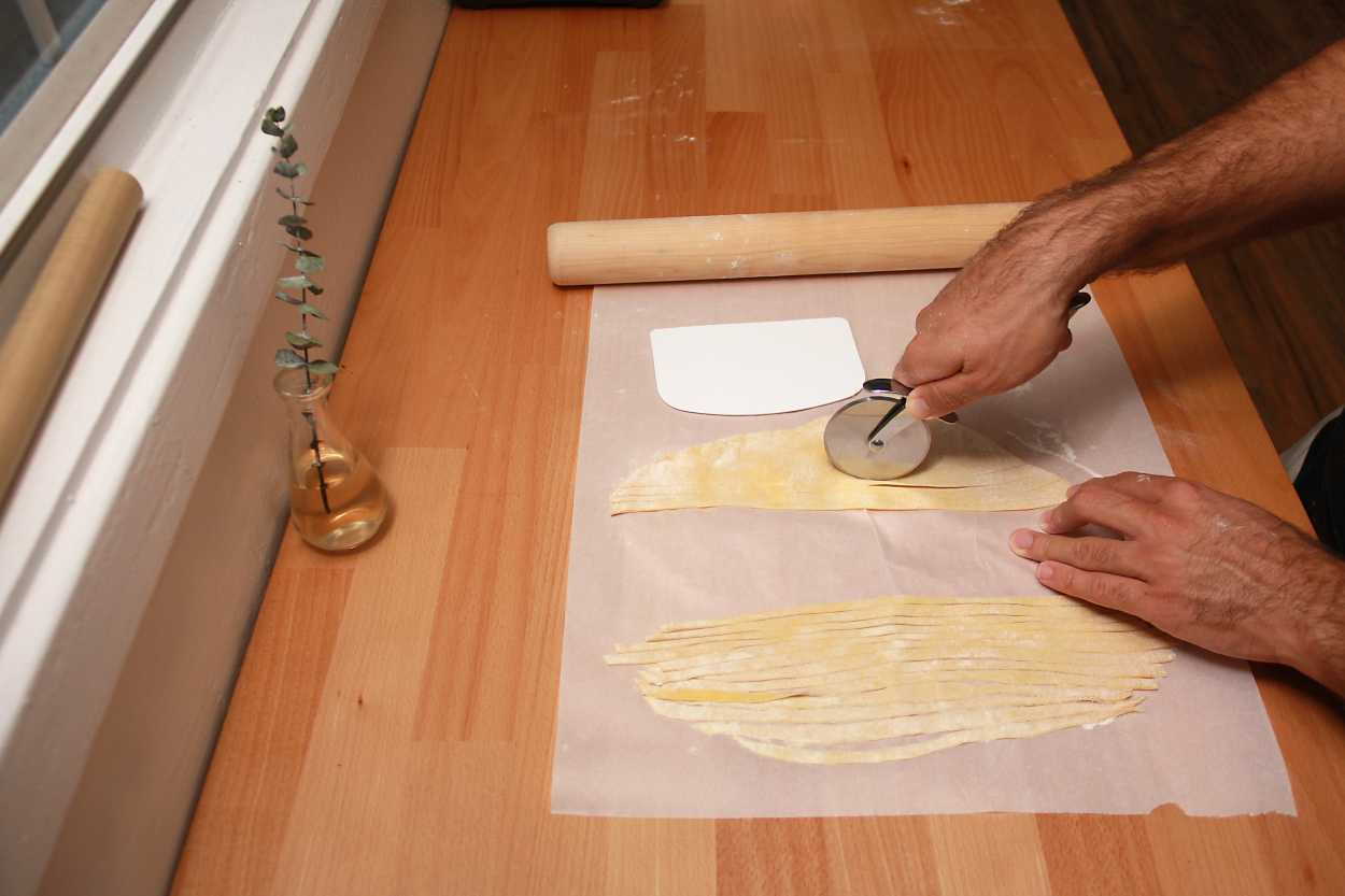 Michael cuts pasta with a pizza cutter