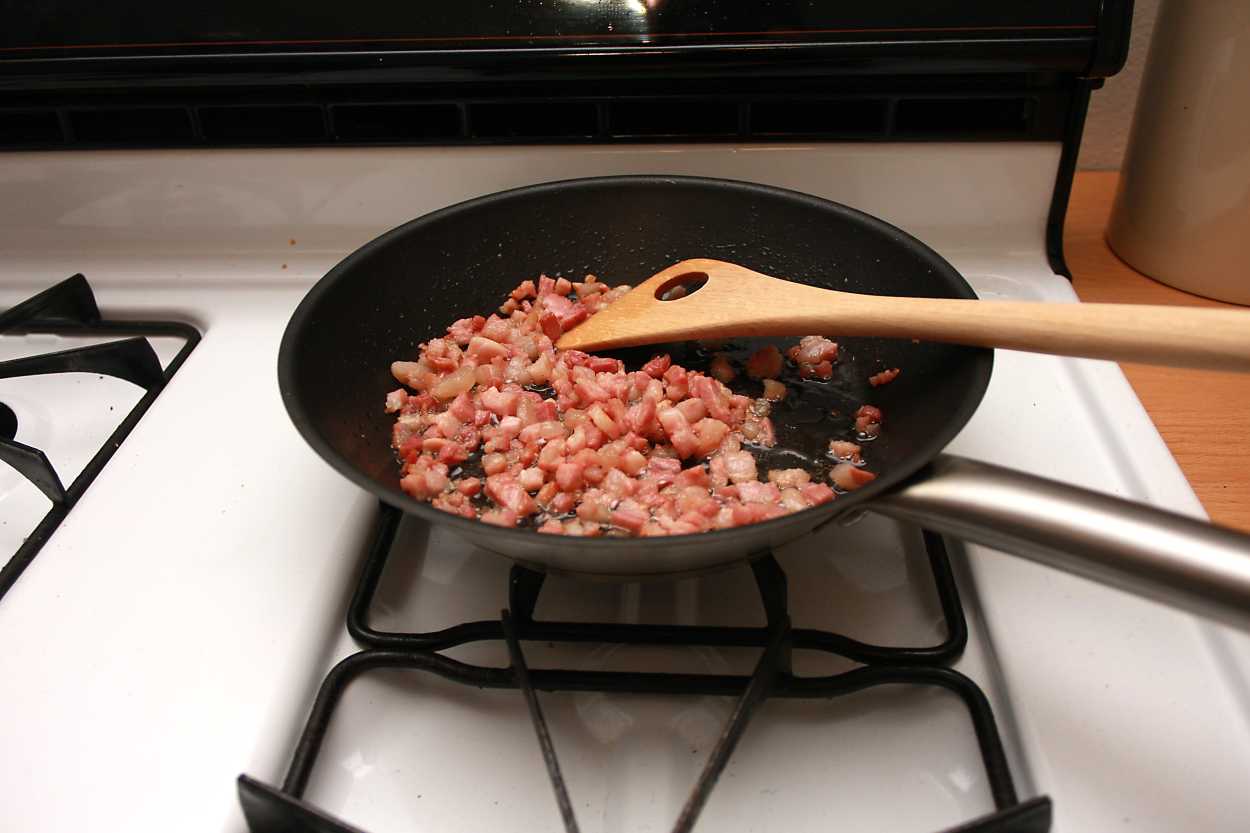 Alyssa stirs pancetta in a pan