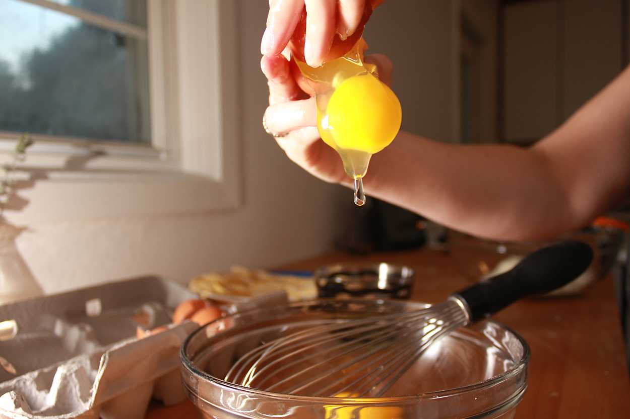 Alyssa drops an egg into a bowl