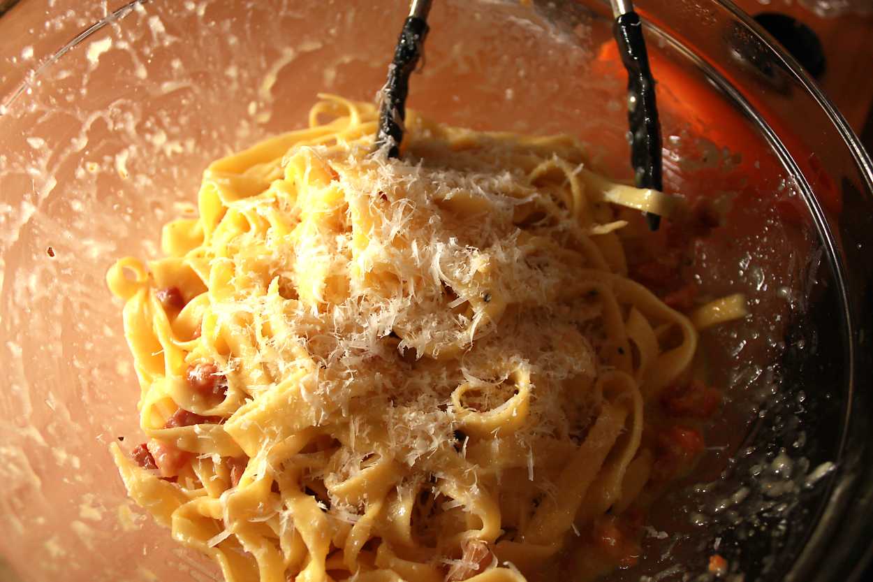 A bowl of just-made carbonara with grated cheese on top