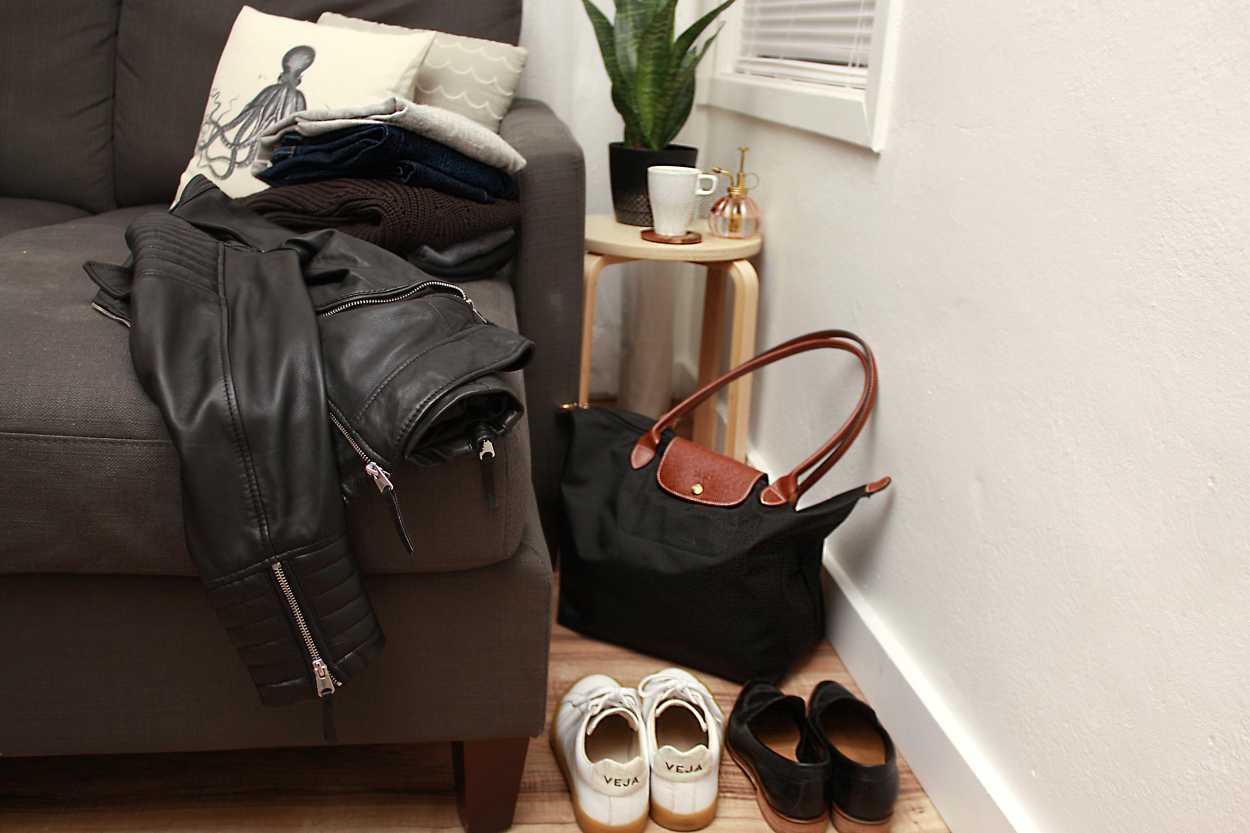 A sofa piled with items packed for NYC in the Fall