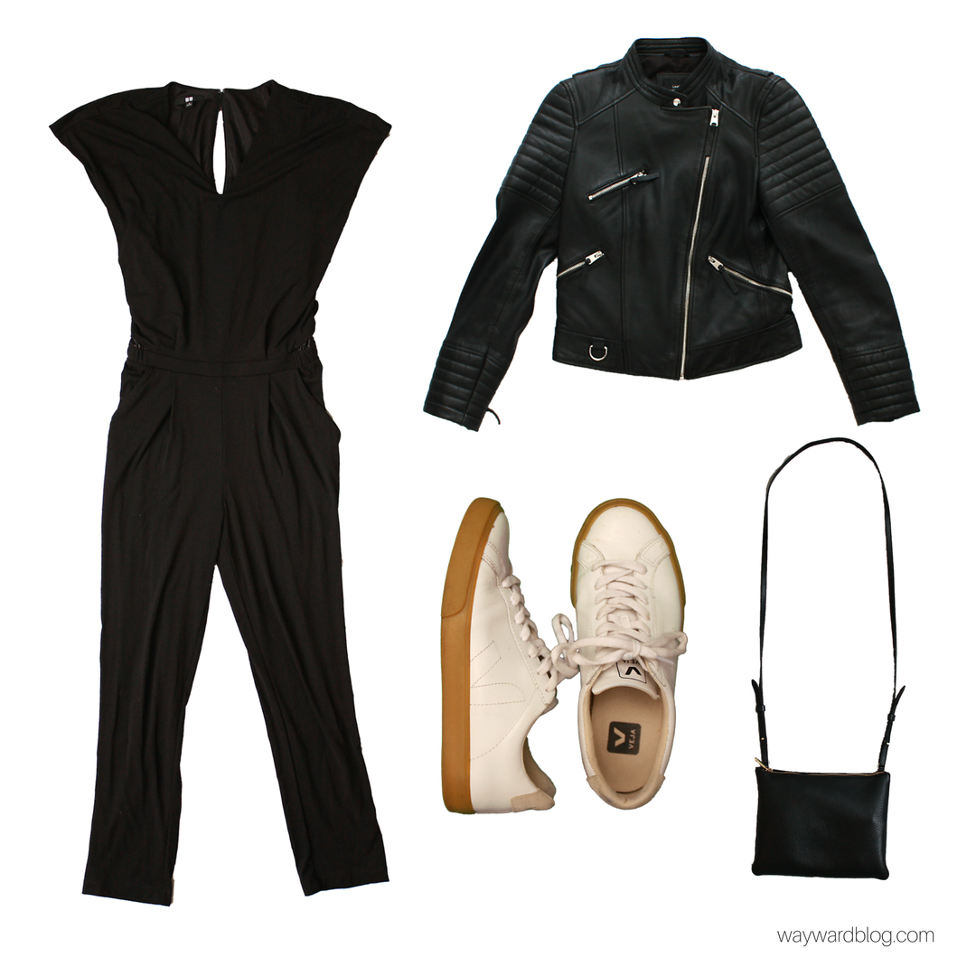 A black jumpsuit, white sneakers, black leather jacket, and purse