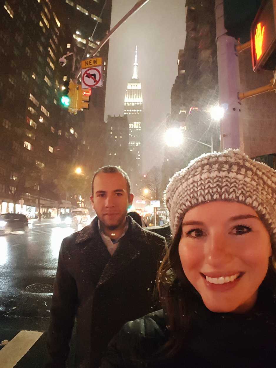 Alyssa and Michael in the snow in NYC - the Empire State Building is in the background