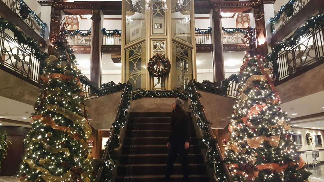Alyssa stands in the lobby of the Biltmore Providence, which is decorated for Christmas