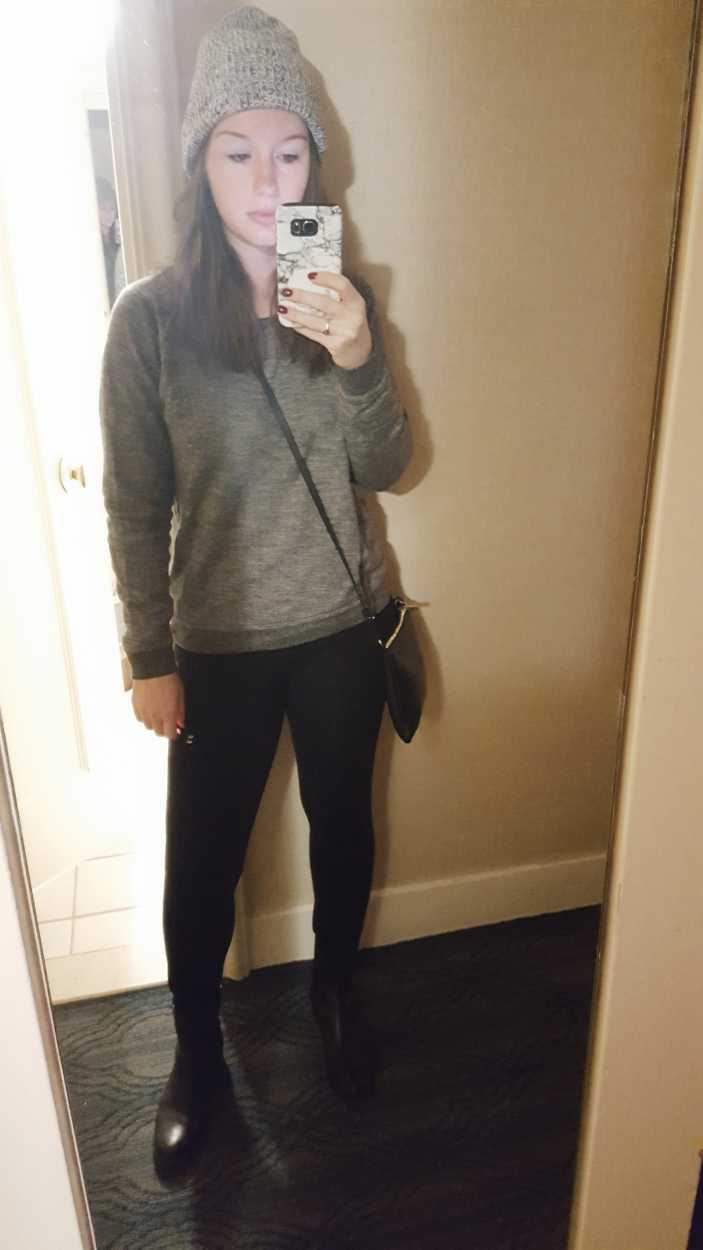 Alyssa wears a sweatshirt, jeans, beanie, and boots
