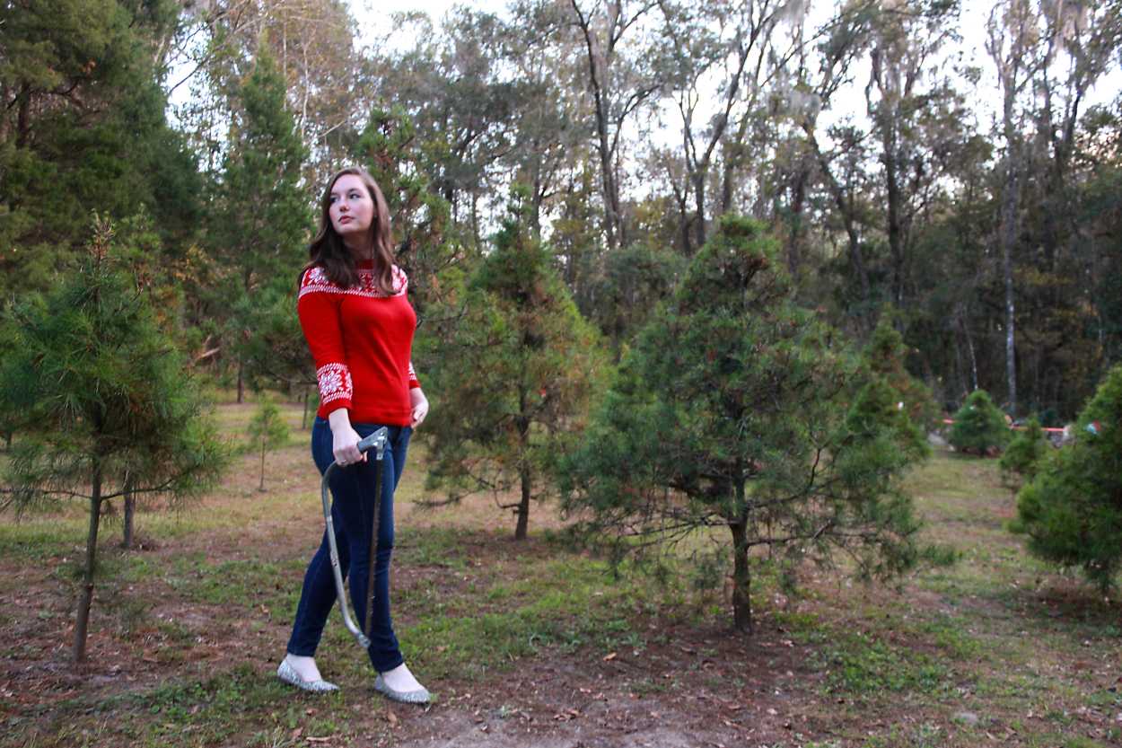 Alyssa in a Christmas Tree Farm with a hand saw