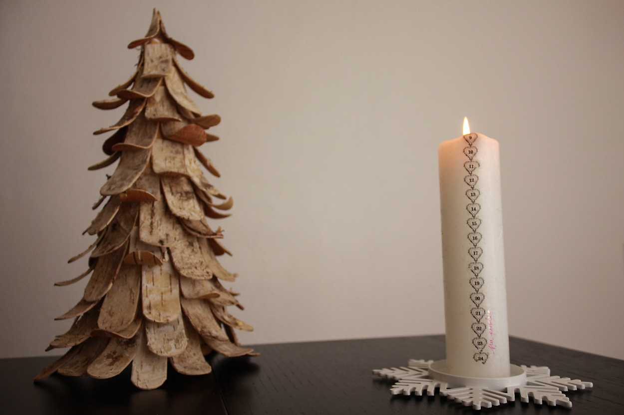 An advent candle with a Christmas Tree decoration