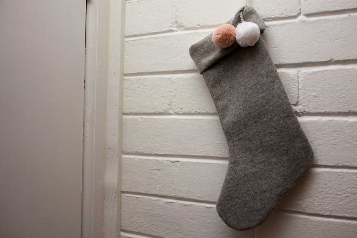 A grey stocking hung on a white brick wall