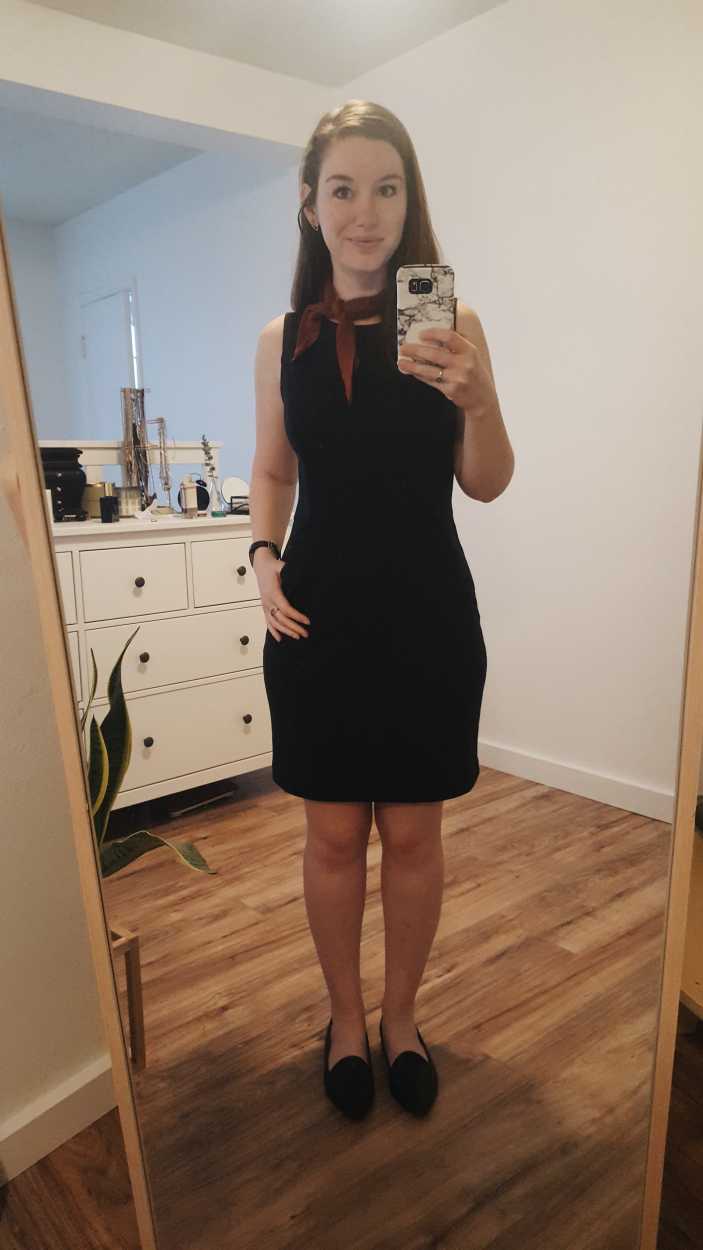 Alyssa wears a black sheath dress with black flats and a rust bandana in the morning