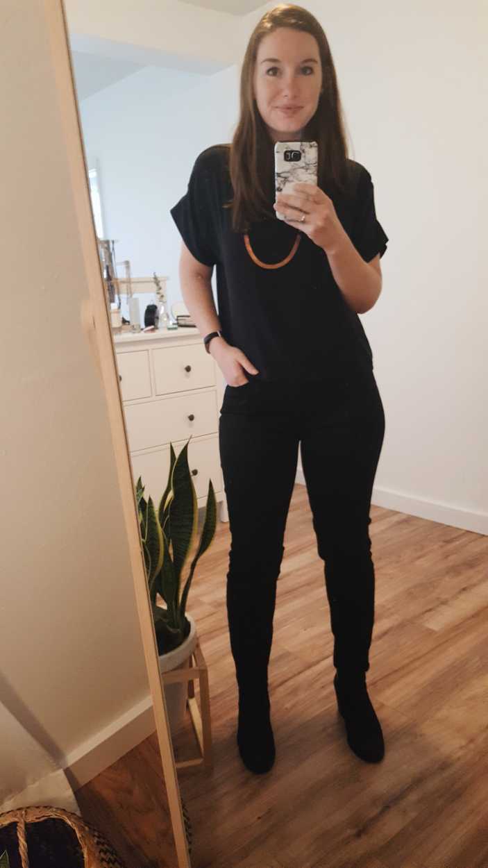 Alyssa wears a black silk tee with black jeans and boots in the afternoon