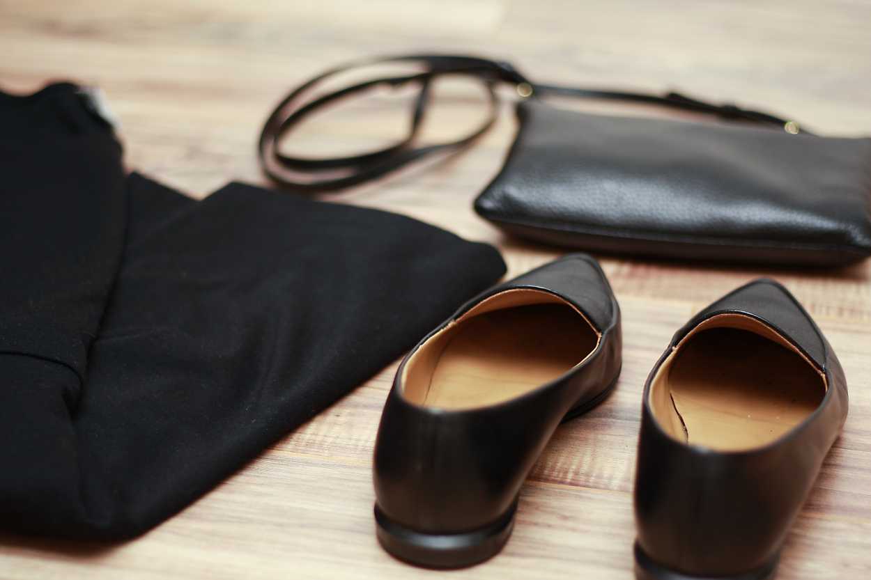 A pair of Everlane modern point shoes with a black purse