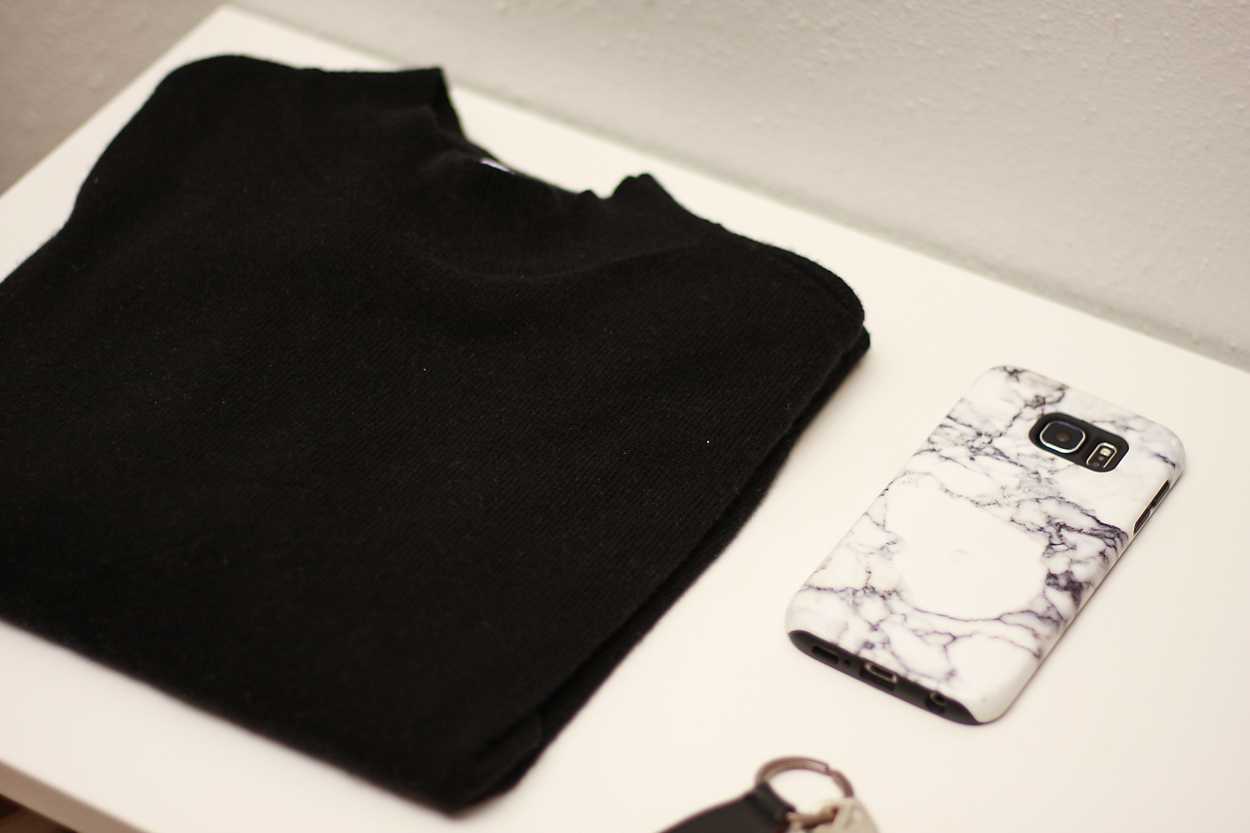 An Everlane Cashmere sweater sits on a white table