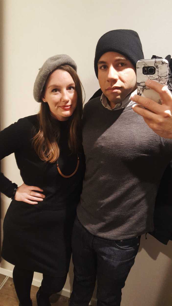 Alyssa and Michael wear clothing for a winter dinner out. She is wearing a black dress with a grey beret