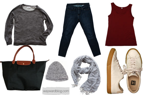 An outfit for wearing on the airplane, with a grey sweatshirt, blue jeans, sneakers, and tote