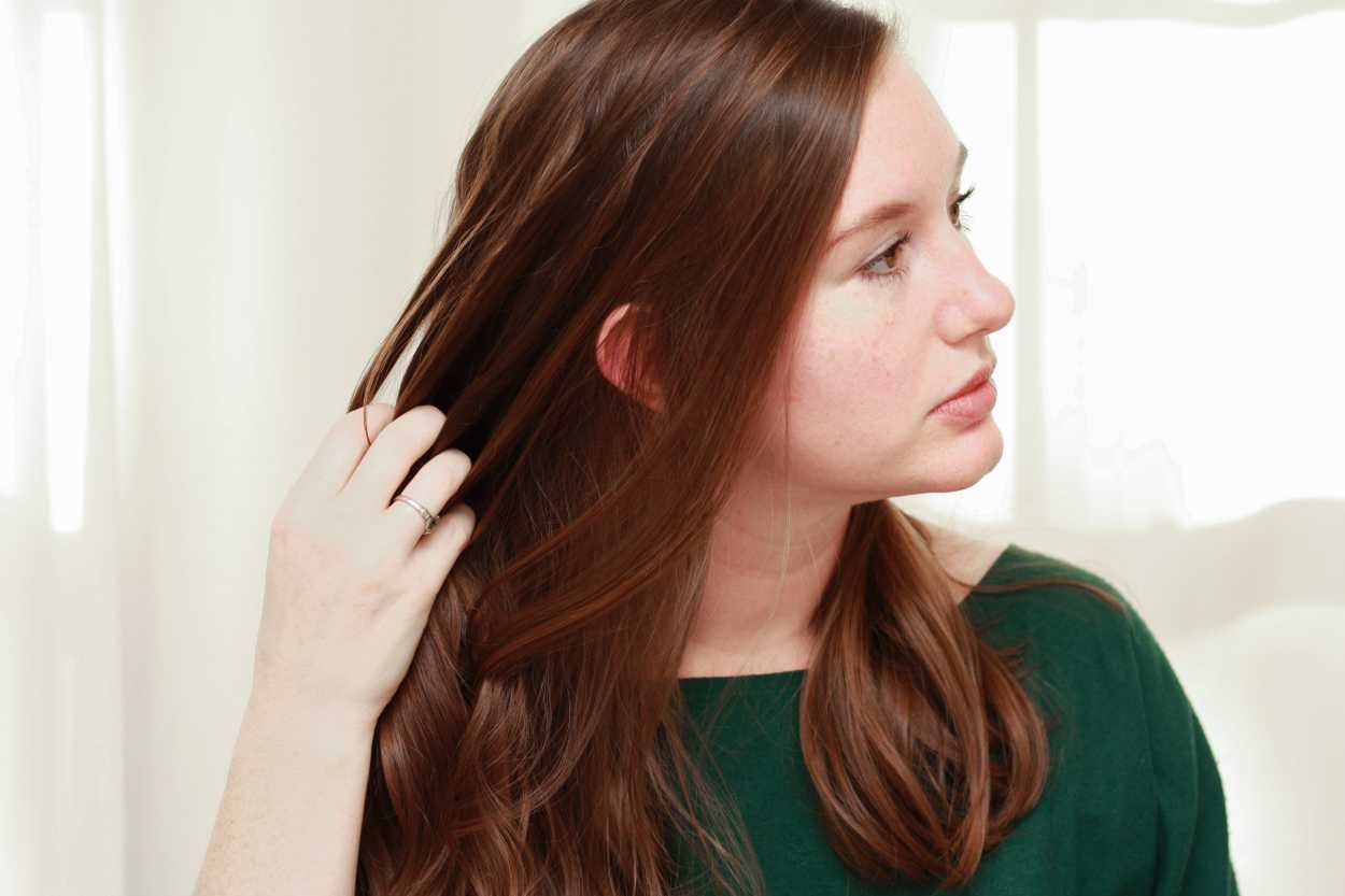 a woman combing her hair with her fingers