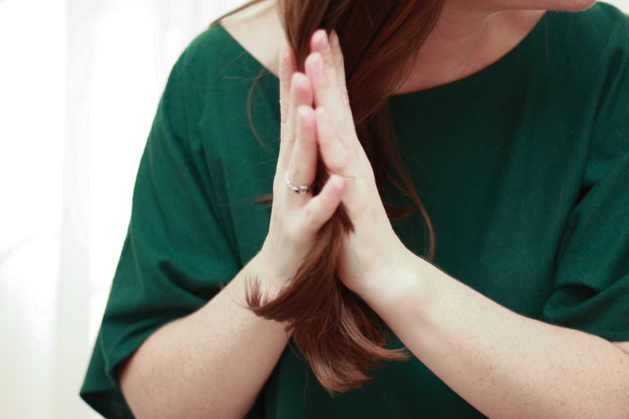 a woman adding hair oil to her hair