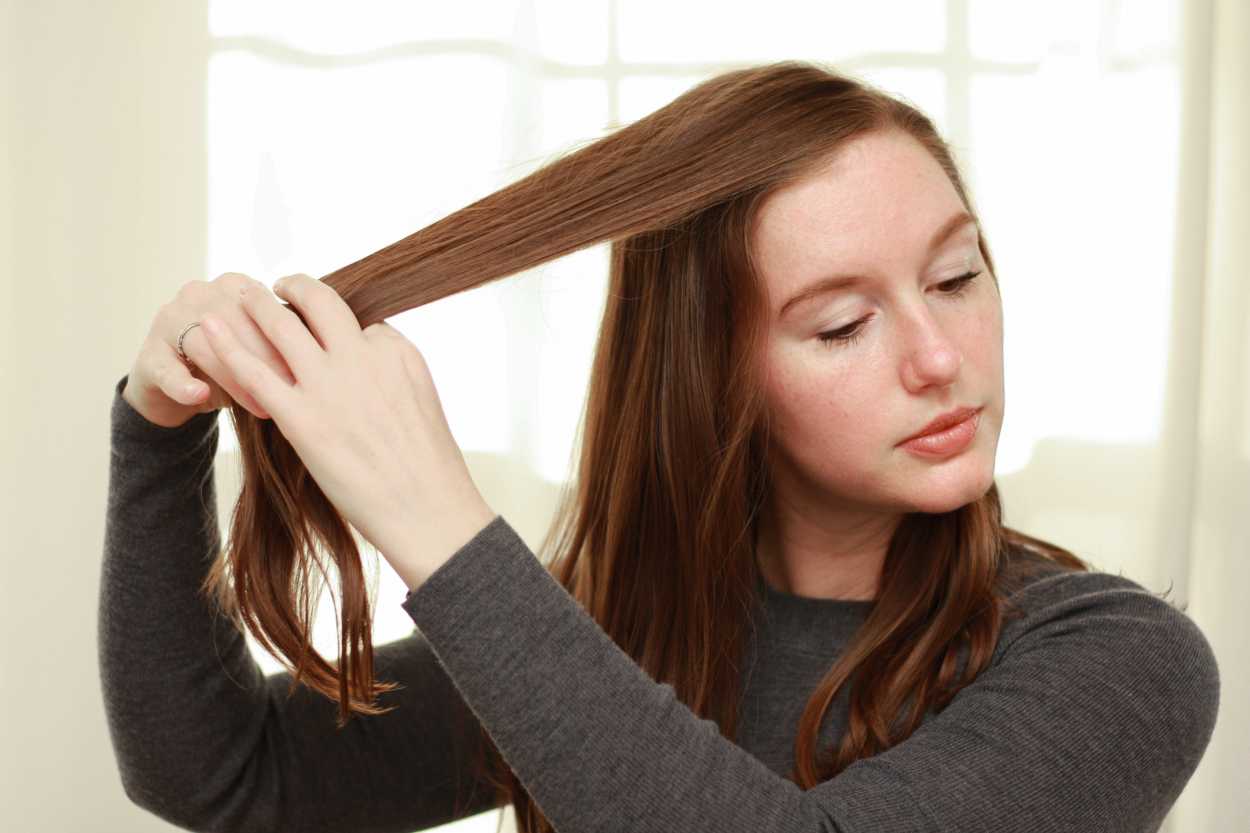 a woman adjusting her hair part