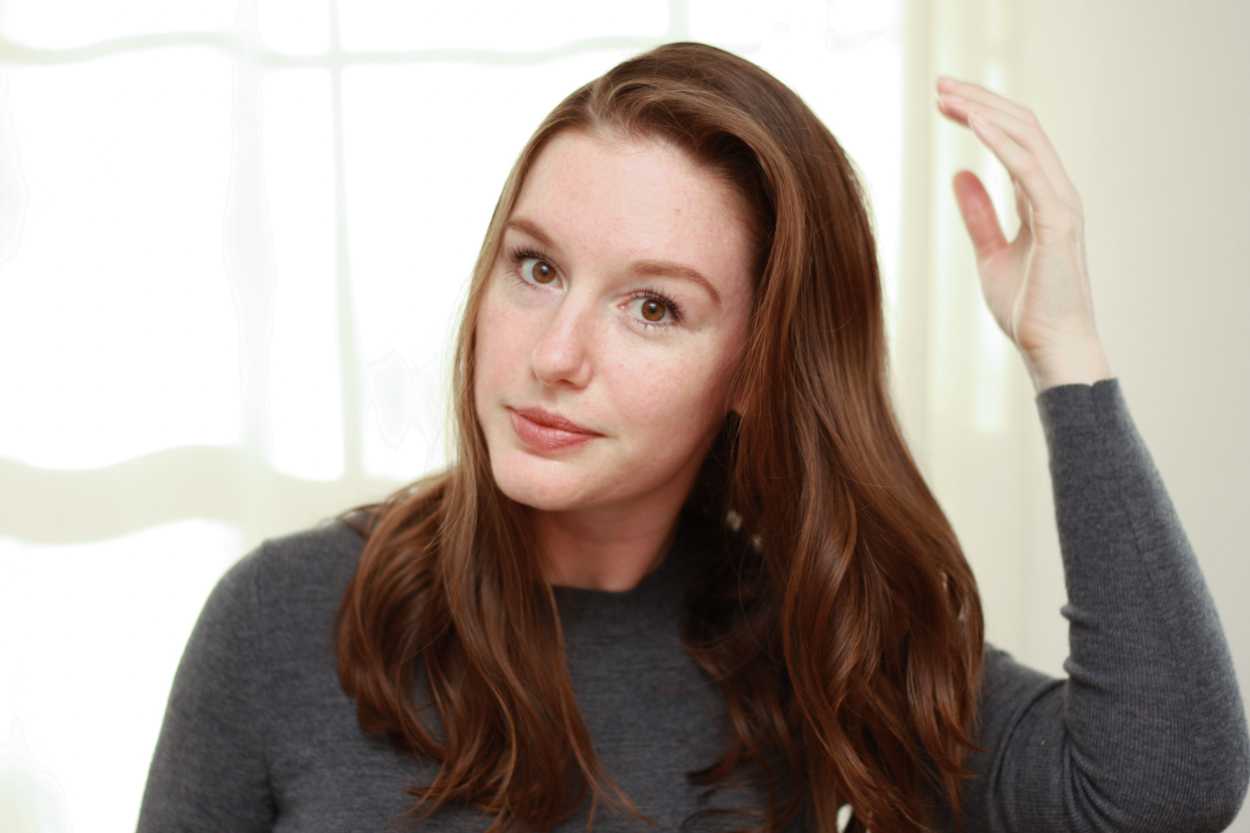 a woman adjusting her hair part