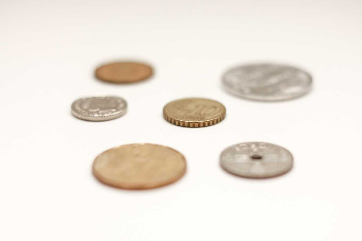 Six coins from different countries sit on a counter