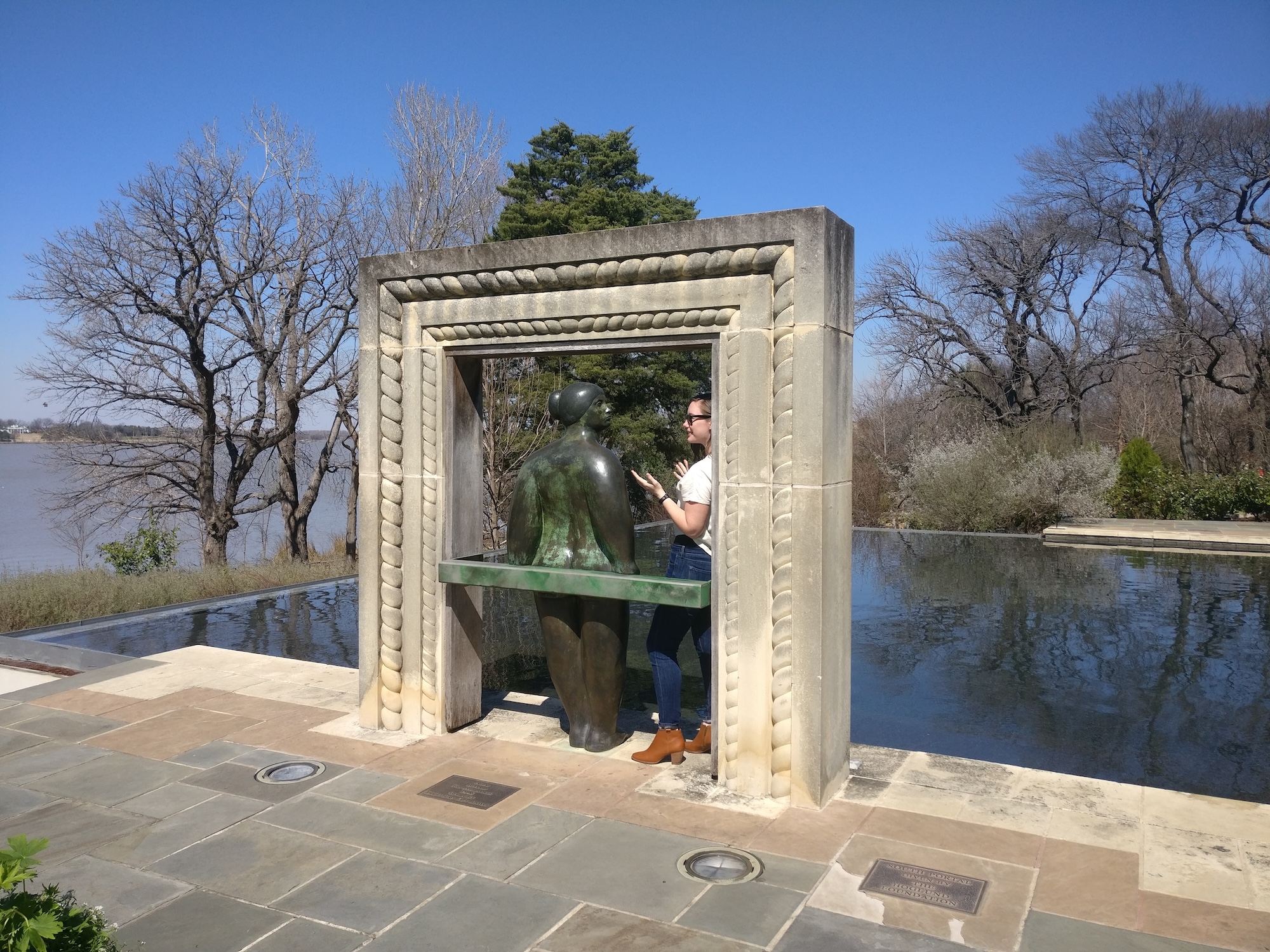 Alyssa pretends to have a conversation with a sculpture at the botanical gardens