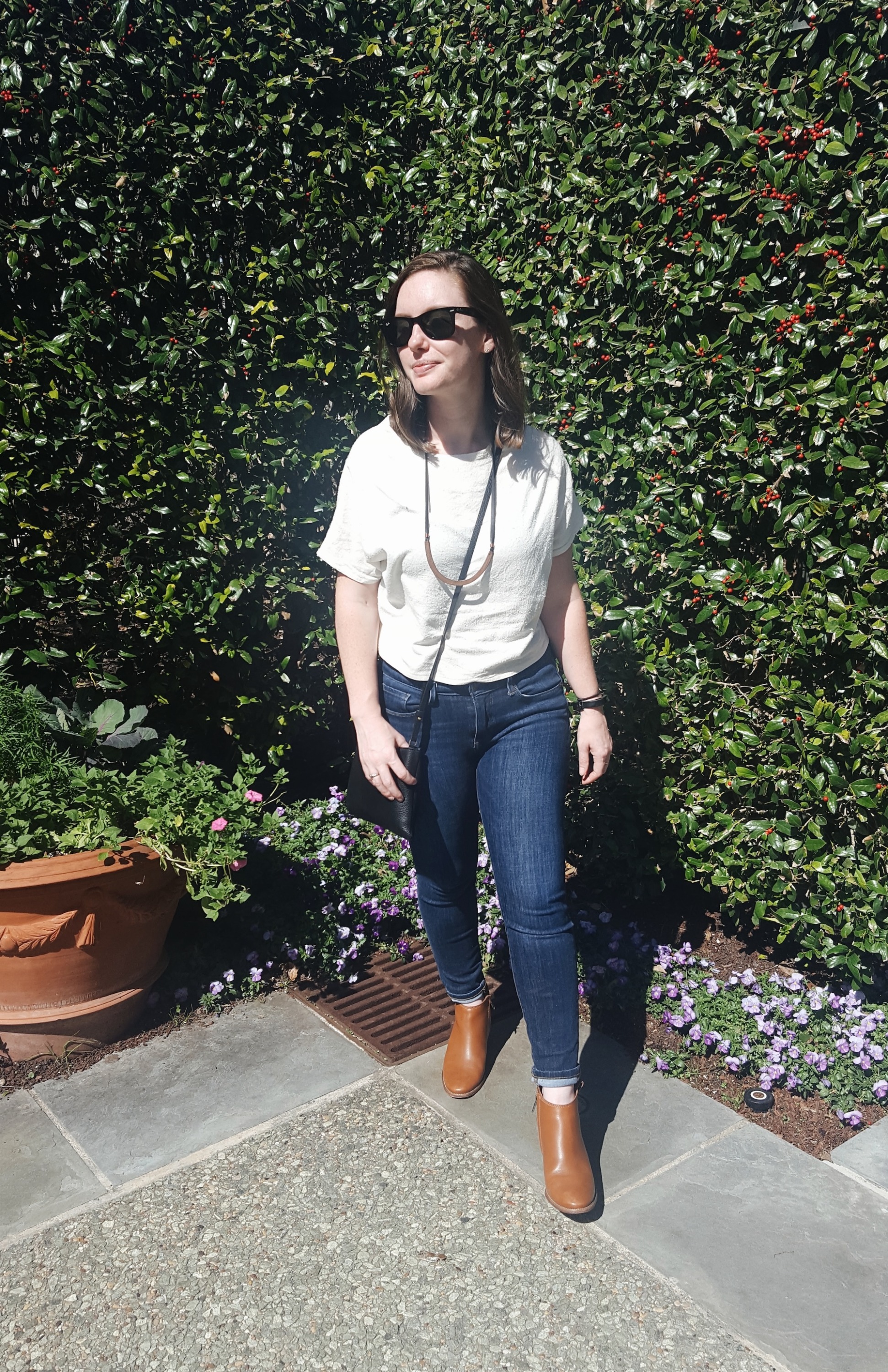 Alyssa stands near plants at the botanical gardens